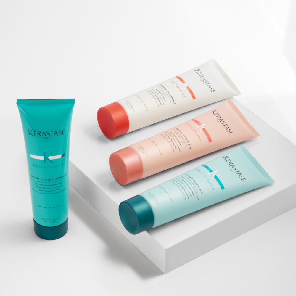 Kérastase Nutritive, Discipline y Resistance Thermique se muestran en una sencilla plataforma gris sobre un fondo gris puro.