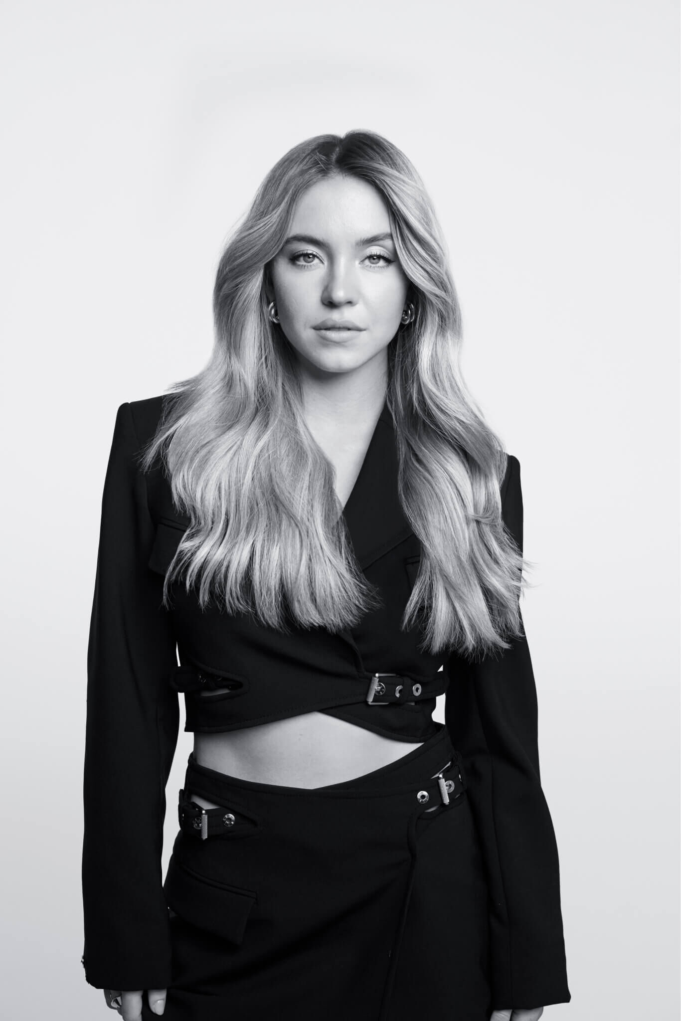 Sydney Sweeney vistiendo un conjunto negro. Ella es actriz, productora, mecánica y también embajadora de Kérastase.