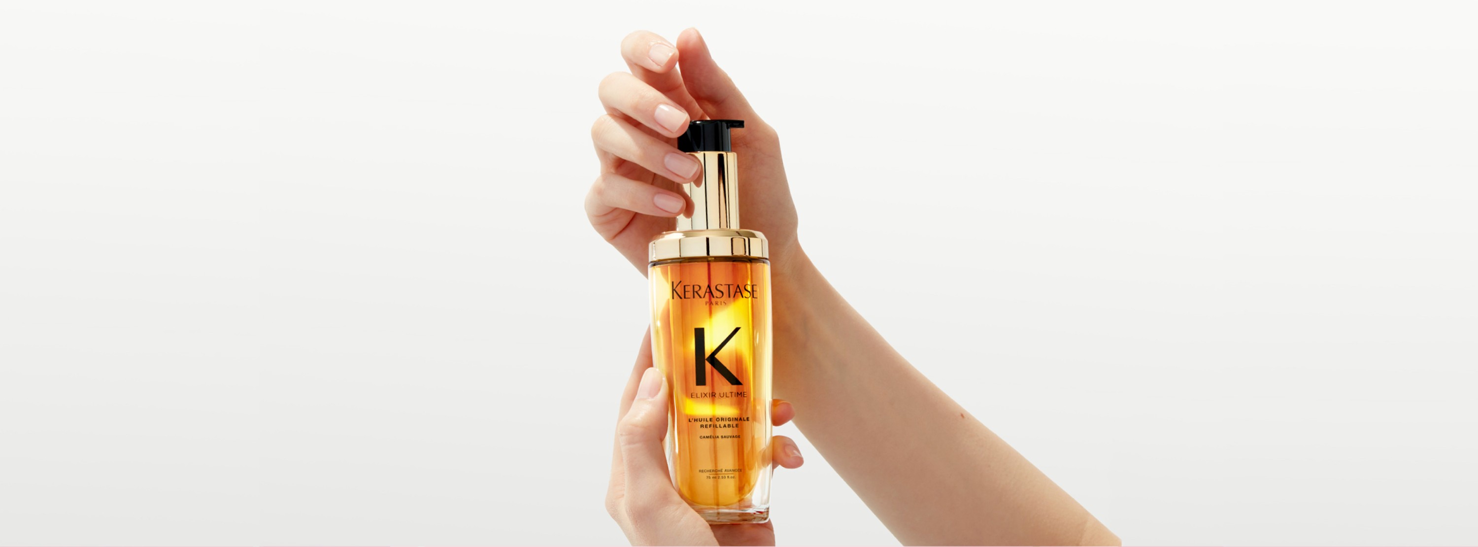 El nuevo Elixir Ultime recargable se sostiene entre dos manos con un movimiento giratorio.